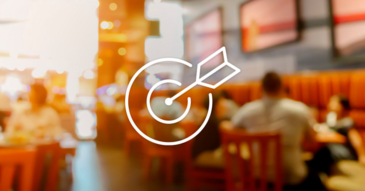 Target with arrow in bullseye over restaurant background showing precision in hospitality marketing from the Eat With Your Eyes: Hospitality Industry Marketing Strategy article by Design At Work