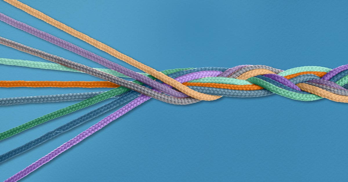 Multicolored braids on blue background showing strands of marketing joining into integrated communication from the What Is the Difference Between Marketing Communication and Integrated Marketing Communication article by Design At Work
